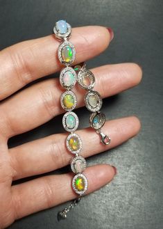 "Gorgeous high quality 100% NATURAL Opal bracelet with cubic Zirconia. Solid 925 sterling silver. Opals are 5x7mm. Oval shape. Measurements: 16cm (6.299\") Extension chain: 2cm (0.787\") Shipped in a beautiful box. Shipping within 24 hours with a tracking number and signature confirmation. Thank you very much for looking." Dazzling Sterling Silver Bracelets With Sparkling Stones, Sterling Silver Bracelet With Sparkling Stones For Anniversary, Hallmarked Cubic Zirconia Tennis Bracelet, Silver Tennis Bracelet With Gemstones, Luxury Silver Bracelet With Halo Setting, White Gold Bracelets With Halo Setting And Cubic Zirconia, Silver Diamond Gemstone Bracelet, Silver Diamond Bracelet With Gemstone, Silver Diamond Bracelets With Halo Setting