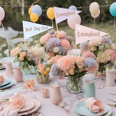 the table is set with pink, blue and yellow flowers in vases on plates