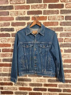 You're looking at a vintage denim jacket by Plain Pockets. This jacket is in good vintage condition, it has a button front closure, side hand warmer pockets, button flap breast pockets, button cuffs and a hidden inside pocket. This jacket would make a great addition to your wardrobe. Don't miss out on this great vintage piece. For best fit check measurements below  Note: jacket has some staining on the front and sleeve(see pictures)as is sale  Approx Measurements- Armpit to Armpit- 21.5" Shoulde Vintage Denim Outerwear, Vintage Denim Jacket With Snap Buttons For Spring, Vintage Single Breasted Denim Jacket For Fall, Classic Single Breasted Medium Wash Denim Jacket, Vintage Denim Jacket With Buttons For Winter, Vintage Single Breasted Denim Jacket For Winter, Vintage Denim Jacket With Patch Pockets For Winter, Vintage Denim Jacket Medium Wash For Winter, Retro Outerwear With Pockets In Medium Wash