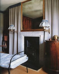 a bedroom with a bed, mirror and fireplace