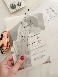 a person holding up a wedding card with an image on it