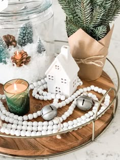 a wooden tray topped with a candle and christmas decorations