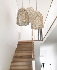 two lamps hanging from the ceiling above some stairs