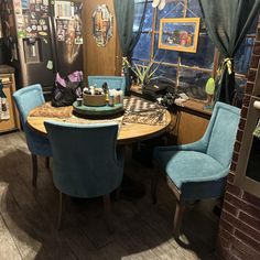 a kitchen with blue chairs and a round table