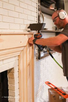 a man with headphones on working on a fireplace