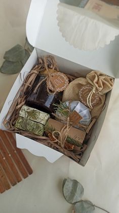 an open gift box containing soaps, tea bags and other items on a table