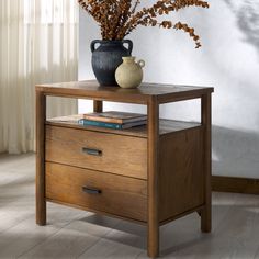 a wooden table with two drawers and a vase on top