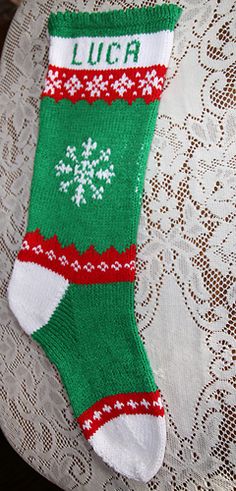 a green and white christmas sock sitting on top of a table