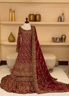 a mannequin with a red and gold dress on display in front of shelves