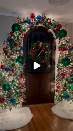 two decorated christmas trees in front of a door