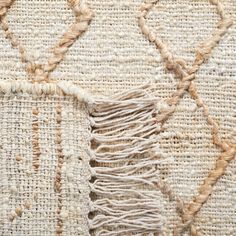 an area rug with fringes on top of it and some other things in the background