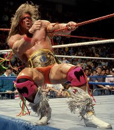 an image of a wrestler in the middle of a wrestling ring with people watching from the stands