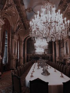 a fancy dining room with chandelier and white table cloths on the tables