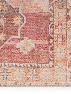 an orange and beige rug with ornate designs on the bottom, in front of a white background