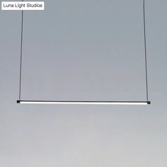 an overhead light fixture suspended in the air with wires attached to it's sides