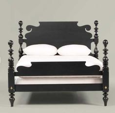 a black bed with white sheets and pillows on it's headboard, in front of a white background