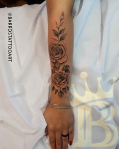 a woman's arm with a rose tattoo on her left arm and the other hand