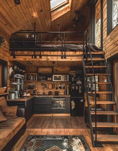 a loft style home with stairs leading up to the loft bed and kitchenette area