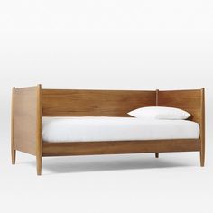 a wooden bed with white sheets and pillows on it's headboard is shown