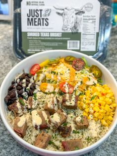 a bowl filled with rice, meat and veggies next to a container of just meats