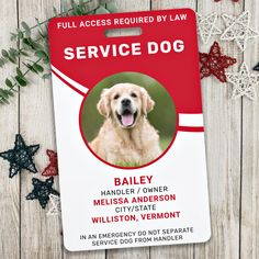 a red service dog id badge sitting on top of a white wooden table next to snowflakes