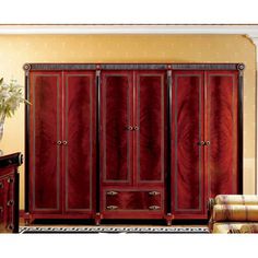 a red armoire in a living room next to a couch