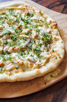 a pizza sitting on top of a wooden cutting board