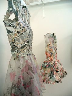 two dresses hanging on a wall next to each other