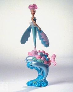 there is a figurine that looks like the little mermaid on top of a wave