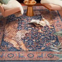 two chairs sitting on top of a rug in front of a table with a book