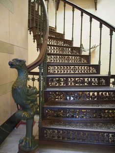 an ornate staircase with wrought iron railing and handrail