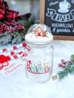 a glass jar filled with white frosting next to christmas decorations