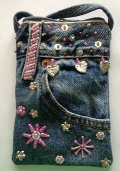 a cell phone case made out of jeans with beading on the bottom and sides