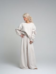 Find your comfort zone in our ecru loungewear set, a perfect marriage of style and relaxation. This ensemble, made from a cotton and polyester blend, provides both the softness of cotton and the durability of polyester. The set includes a relaxed-fit sweatshirt and coordinating wide-leg pants, both designed to offer you a luxurious feel and a chic, understated look. FEATURES: Oversized sweatshirt with drop shoulders for a modern silhouette. High-rise with a wide-leg cut to complement the relaxed Beige Relaxed Fit Sweatpants For Everyday, Beige Relaxed Fit Sleepwear Sets, Beige Cotton Sets With Relaxed Fit, Cream Cozy Loungewear Sets, Everyday Beige Cotton Sweatpants, Cozy Cream Loungewear Sets, Cozy Relaxed Fit Beige Sweatpants, Cozy Beige Relaxed Fit Sweatpants, Beige Relaxed Fit Sleepwear For Lounging