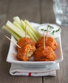 two appetizers on a plate with toothpicks and celery sticks