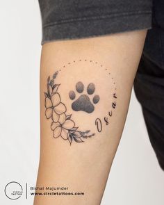 a dog's paw and flower tattoo on the arm