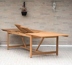 a wooden table sitting in front of a brick wall