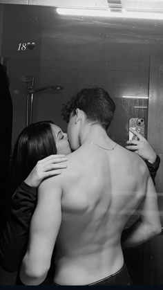 black and white photograph of a man hugging a woman in front of a bathroom mirror