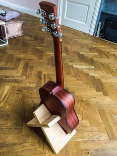 a guitar stand made out of cardboard on the floor