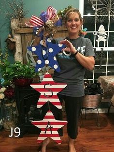 a woman standing in front of a wooden star with an american flag decoration on it