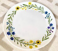 a white plate with yellow and blue flowers on it