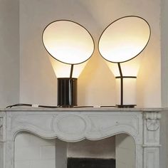 two lamps sitting on top of a fireplace