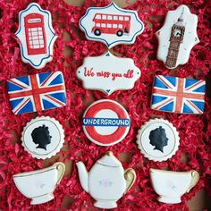 decorated cookies in the shape of british flags and teapots on red shredded paper