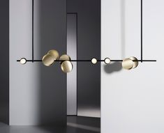 three lights are hanging from the wall in front of two mirrored walls and one light is turned on