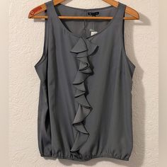 Women’s Sleeveless Blouse From Gap. Nwt Xxl But Fits More Like And Xl. Would Look Great Under A Blazer. Ruffles Down The Front And Elastic On The Bottom Armpit To Armpit 23” Length 26” Gray Chic Sleeveless Tops By Gap, Chic Sleeveless Gap Tops, Gap Ruffled Tops For Summer, Summer Ruffled Tops By Gap, Summer Ruffled Tops From Gap, Elegant Sleeveless Gray Tops, Spring Gap Cami Tops, Gap Spring Cami Tops, Gap Cami Tops For Spring