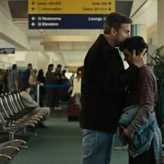 two people standing next to each other at an airport