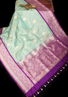 This Seafoam Tone Tissue Banarasi Saree is a delightful fusion of elegance and grace, perfect for special occasions. Crafted from delicate tissue fabric, it drapes with a gentle flow, exuding a subtle sheen that enhances its allure. The seafoam tone, reminiscent of tranquil waters, imparts a sense of serenity and sophistication to the saree, making it an enchanting choice for any event. Adorning the saree are exquisite Floral Zari Motifs delicately woven throughout the fabric. These shimmering motifs, crafted with fine metallic threads, add a touch of opulence and charm to the saree, lending it an ethereal beauty. Each motif showcases the intricate craftsmanship of Banarasi weavers, highlighting their expertise in traditional techniques. The saree is further enhanced by Contrast Zari Borde Fusion Style Wedding Saree For Diwali, Wedding Fusion Saree For Diwali, Fusion Style Wedding Dupatta With Zari Work, Celebration Tussar Silk Traditional Wear With Meenakari, Fusion Style Wedding Dupatta With Traditional Drape, Celebration Traditional Wear With Meenakari In Tussar Silk, Fusion Style Wedding Dupatta For Diwali, Fusion Style Tissue Silk Saree With Pallu, Pista Green Traditional Wear With Cutdana For Celebrations