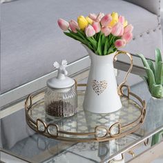 a glass tray with flowers on it and a vase filled with tulips in the center