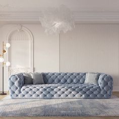 a living room with a blue couch, rug and chandelier in the corner