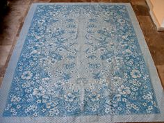 a blue and white rug sitting on top of a tile floor